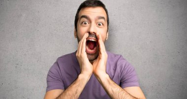 Yakışıklı adam bağırıyor ve dokulu duvar üzerinde bir şey duyurdu