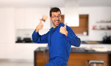 Ressam adam bir başparmak yukarı jest vererek evde başarı vardı çünkü