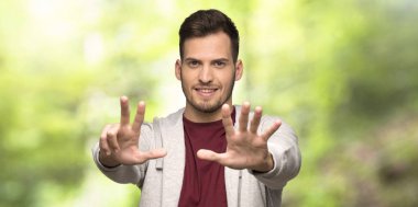 Sweatshirt ile bir parkta parmaklarla sekiz sayma adam