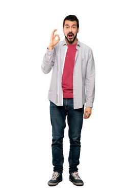 Yakışıklı adamın sakalı şaşırmış ve izole beyaz arka plan üzerinde gösteren ok işareti ile tam uzunlukta atış