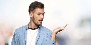 Yakışıklı adam boşaltmak hayali avuç içinde tutan açık havada bir reklam eklemek için