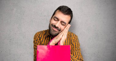 Dokulu duvar üzerinde aşkım ifade uyku jest yapma alışveriş çantaları ile adam