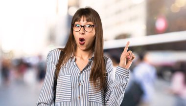 Gözlük ile kadın açık havada parmak işaret bir fikir düşünme