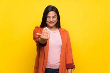 Sarı duvarın üzerindeki genç Kolombiyalı kız elini uzatmaya davet ediyor. Gelmene sevindim.