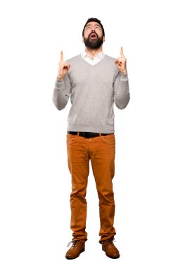 Yakışıklı adam sürpriz ve izole beyaz arka plan üzerinde yukarı işaret