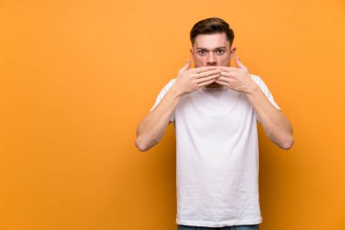 Elleri ile ağız kapsayan kahverengi duvar üzerinde Redhead adam