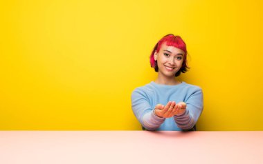Pembe saç bir reklam eklemek için palmiye üzerinde boşaltmak hayali tutan genç kadın