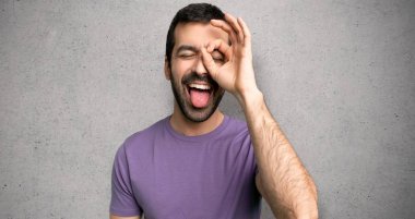 Yakışıklı adam dokulu duvar üzerinde komik ve çılgın yüz duygu yapar