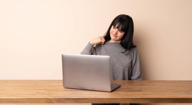 Yorgun ve hasta ifade ile onu laptop ile çalışan genç kadın