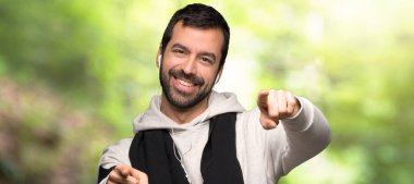 Bir parkta gülümsüyor iken spor adam puan parmak