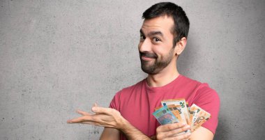 Adam bir fikir sunan bir sürü para alarak dokulu duvara doğru gülümsüyor bakarken