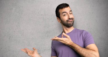 Yakışıklı adam dokulu duvara gelmek için davet için yan eller uzanan