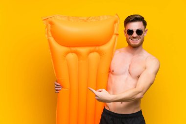 Yaz tatillerinde kızıl saçlı adam parmağını yana doğru gösteriyor