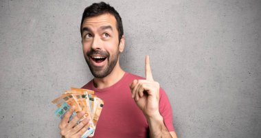 Adam çok para alarak bir fikir dokulu duvar üzerinde parmak işaret düşünme