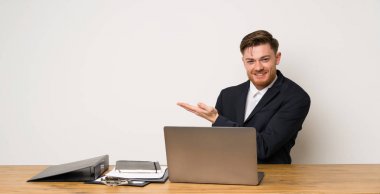 Bir ofiste işadamı doğru gülümseyerek bakarken bir fikir sunan