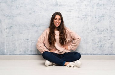 Genç öğrenci kız bir masada okuyor silah ile kalça ve gülümseyen poz