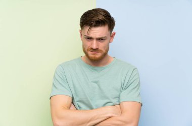 Renkli arka plan üzgün üzerinde Redhead adam