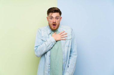 Renkli arka plan üzerinde Redhead adam şaşırttı ve doğru bakarken şok