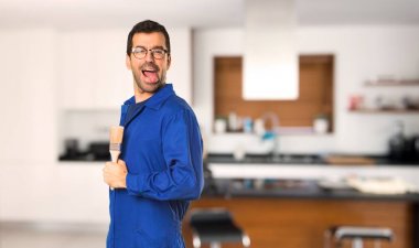 Fotoğraf makinesinde dil gösteren ressam adam evde komik bir görünüm