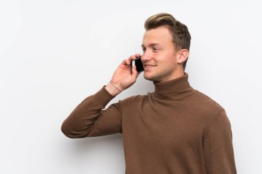 Cep telefonu ile bir konuşma tutarak izole beyaz duvar üzerinde sarışın adam
