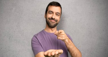 Dokulu duvar üzerine bir reklam eklemek için avuç içinde boşaltmak hayali tutan yakışıklı adam