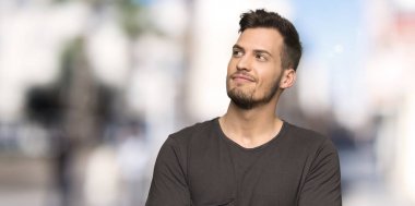 Açık havada gülümseirken siyah gömlek ile adam bakıyor