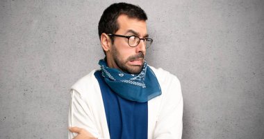 Gözlük ile yakışıklı adam biraz gergin ve dokulu duvar üzerinde diş basmak korkuyor