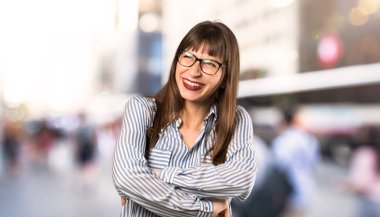 Açık havada gülümseirken gözlük ile kadın bakıyor