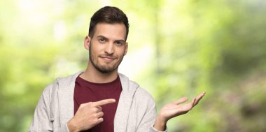 Kazak boşaltmak hayali avuç içinde tutan adamla bir parkta bir reklam eklemek için