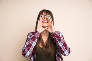 Koyu sarı arka plan açık ağız ile bağırarak üzerinde genç kadın