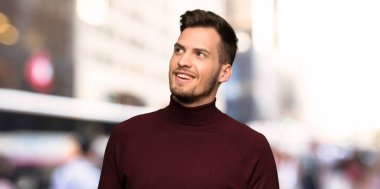 Şehirde gülümseyen balıkçı yaka kazak ile adam