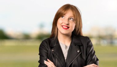 Açık havada gülümsüyor iken genç Redhead kadın bakıyor