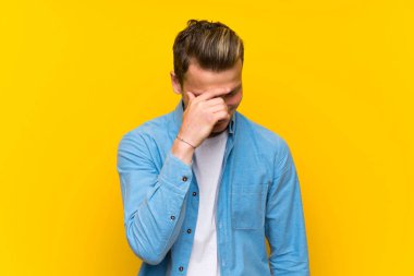 Sarışın yakışıklı adam üzerinde izole duvar gülüyor