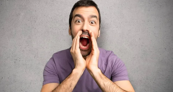 Yakışıklı adam bağırıyor ve dokulu duvar üzerinde bir şey duyurdu