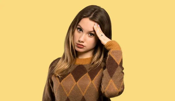 孤立した黄色の背景上の頭痛と茶色のセーターを持つティーンエイジャーの女の子 — ストック写真
