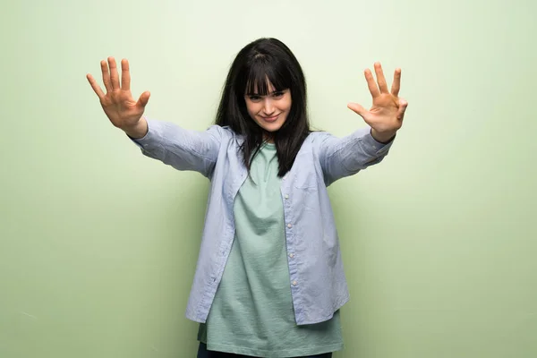 Young Woman Green Wall Counting Nine Fingers — Stock Photo, Image