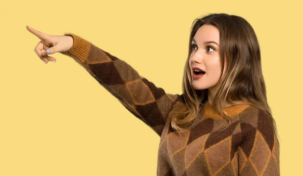 Adolescente Chica Con Suéter Marrón Apuntando Hacia Fondo Amarillo Aislado — Foto de Stock
