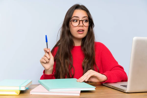 Adolescente estudiante chica estudiando en una mesa pensando — Foto de Stock