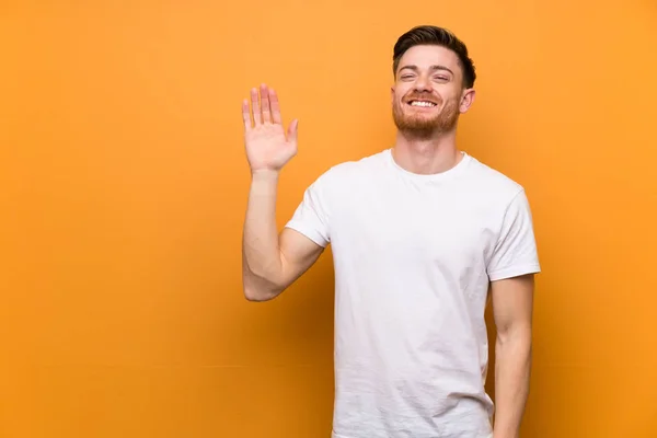 Rude Człowiek Nad Brązową Ścianę Pozdrawiając Ręką Szczęśliwym Wyrazem — Zdjęcie stockowe