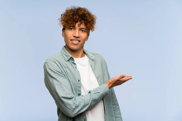 Jonge Afro Amerikaanse Man Geïsoleerde Blauwe Muur Presenteren Een Idee — Stockfoto