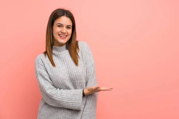 Jovem Mulher Sobre Parede Rosa Apresentando Uma Ideia Enquanto Olha — Fotografia de Stock