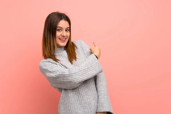 Ung Kvinna Över Rosa Vägg Pekar Tillbaka — Stockfoto