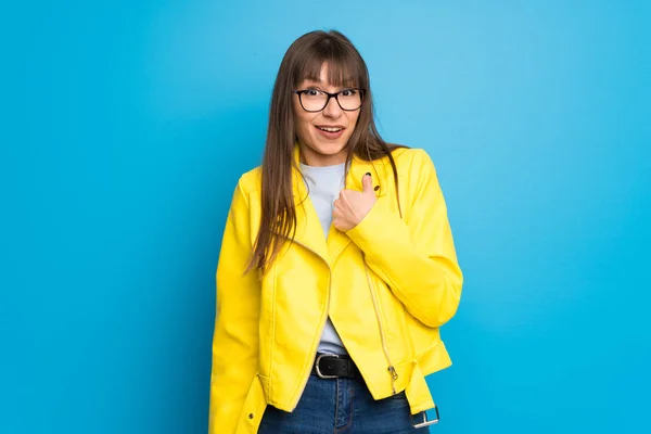 Young Woman Yellow Jacket Blue Background Surprise Facial Expression — Stock Photo, Image