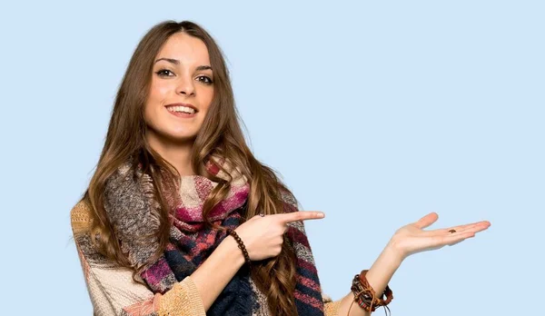 孤立した青の背景の上に広告を挿入するために手のひらに架空の Copyspace を保持している若いヒッピー女性 — ストック写真
