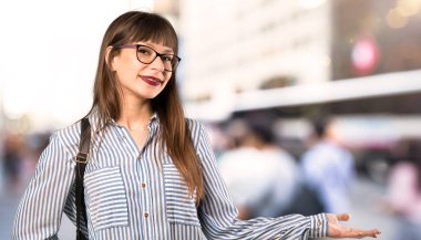 Açık havada gülümsüyor görünümlü gözlük ile kadın bir fikir sunan