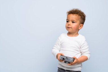 izole mavi arka plan üzerinde çocuk bir kamera tutan