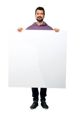 Boş bir afişini izole beyaz arka plan üzerinde tutarak kazak ile yakışıklı adamın tam uzunlukta atış