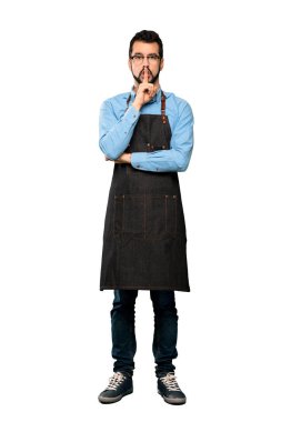 Tam uzunluklu çekim apron ile sessizlik jest gösteren bir işareti ağız izole beyaz arka plan üzerine parmak koyarak