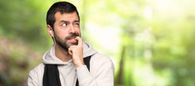 Spor adam bir parkta bakarak şüphe sahip