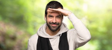 Spor adam uzak el ile bir parkta bir şey bakmak arıyor